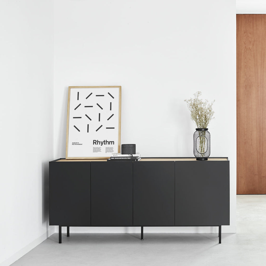 Modern interior with a black sideboard, wooden door, and minimal decor.