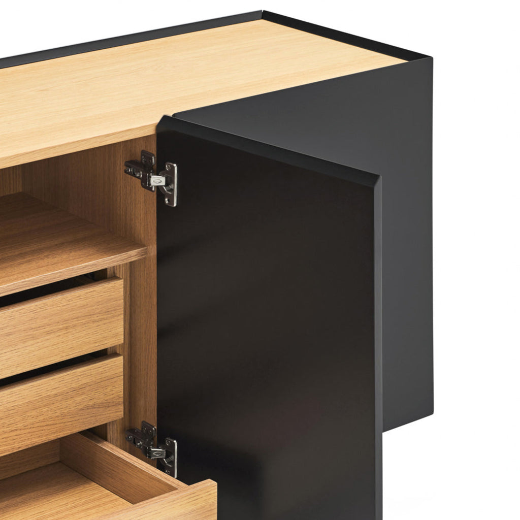 Close-up of a modern cabinet with a matte black door and light natural wood interior and drawer fronts, shown open on a white background.