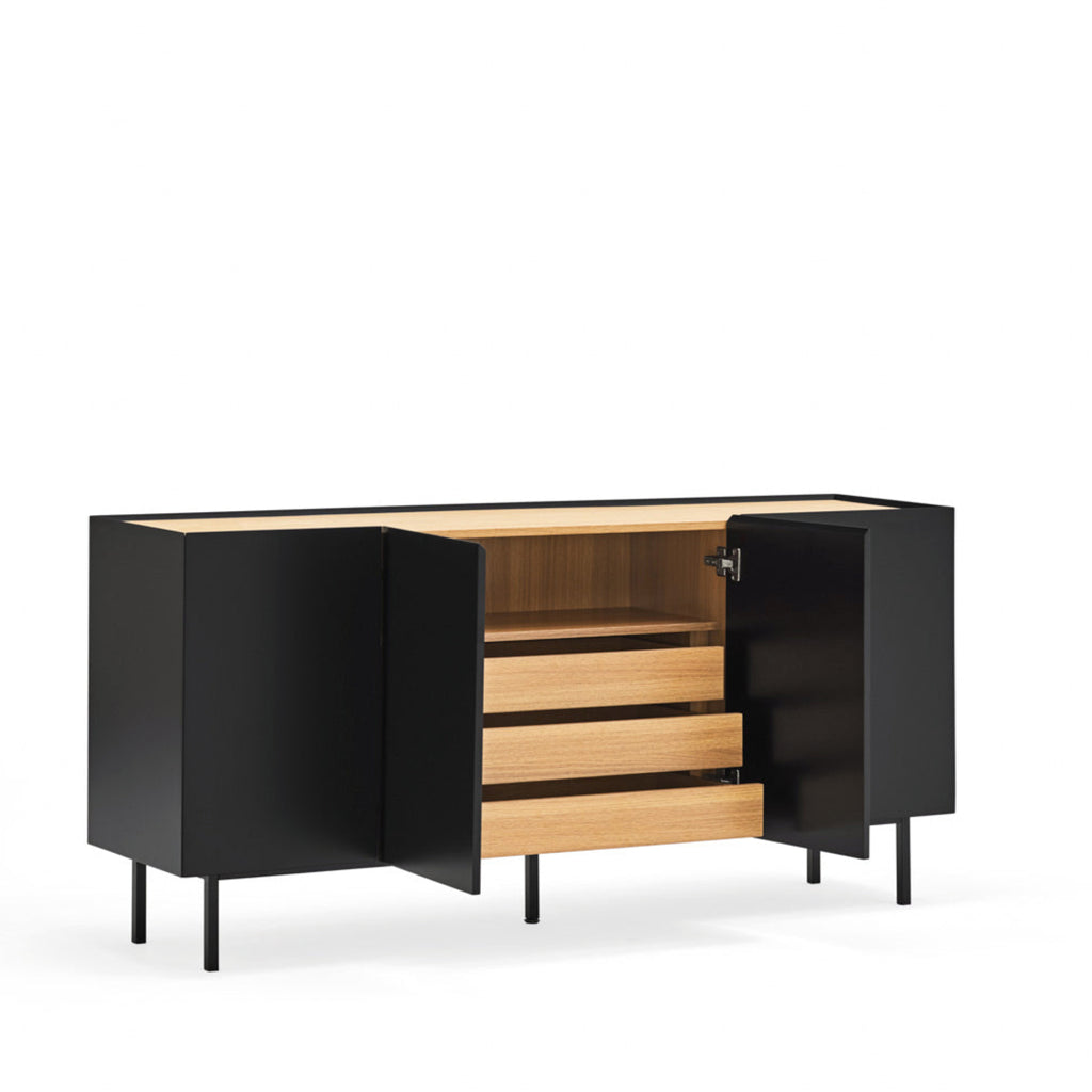 A modern sideboard cabinet with black exterior panels and light wood drawers, shown open in a styled room with a potted plant, wall molding, and a round mirror.