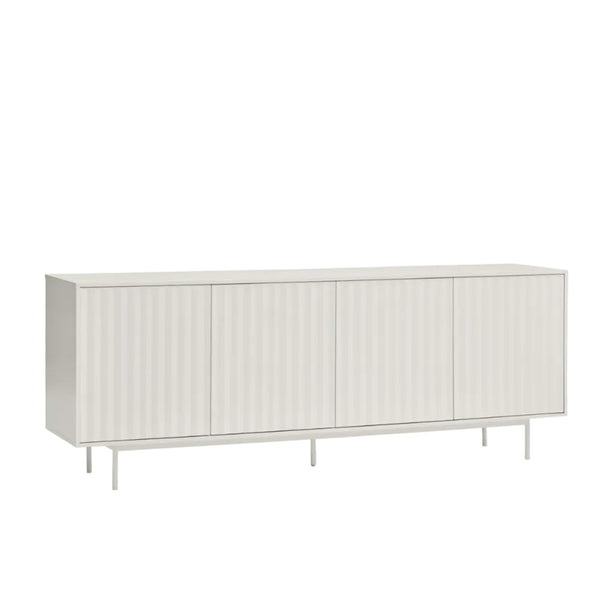 A long, low sideboard cabinet with four vertically ribbed doors, shown in a light warm gray or off-white finish on a clean white background.