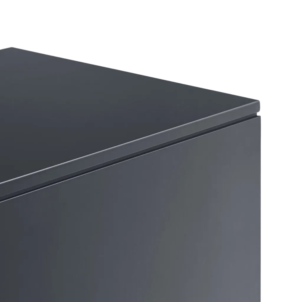Close-up of the corner of a dark charcoal gray appliance, showing the top edge and side panel against a plain white background.