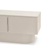 A close-up of a modern low-profile sideboard or media console in a warm off-white or light beige finish, showing the top surface, cabinet doors, and a rounded cylindrical base against a plain white background.