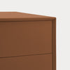 Close-up of a modern two-drawer cabinet or dresser in a warm medium brown finish, showing the top surface and drawer front against a plain light background.