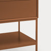 Close-up of a modern cabinet or side table with a warm brown finish, showing the front of a drawer, open shelf, and slim legs against a light gray background.