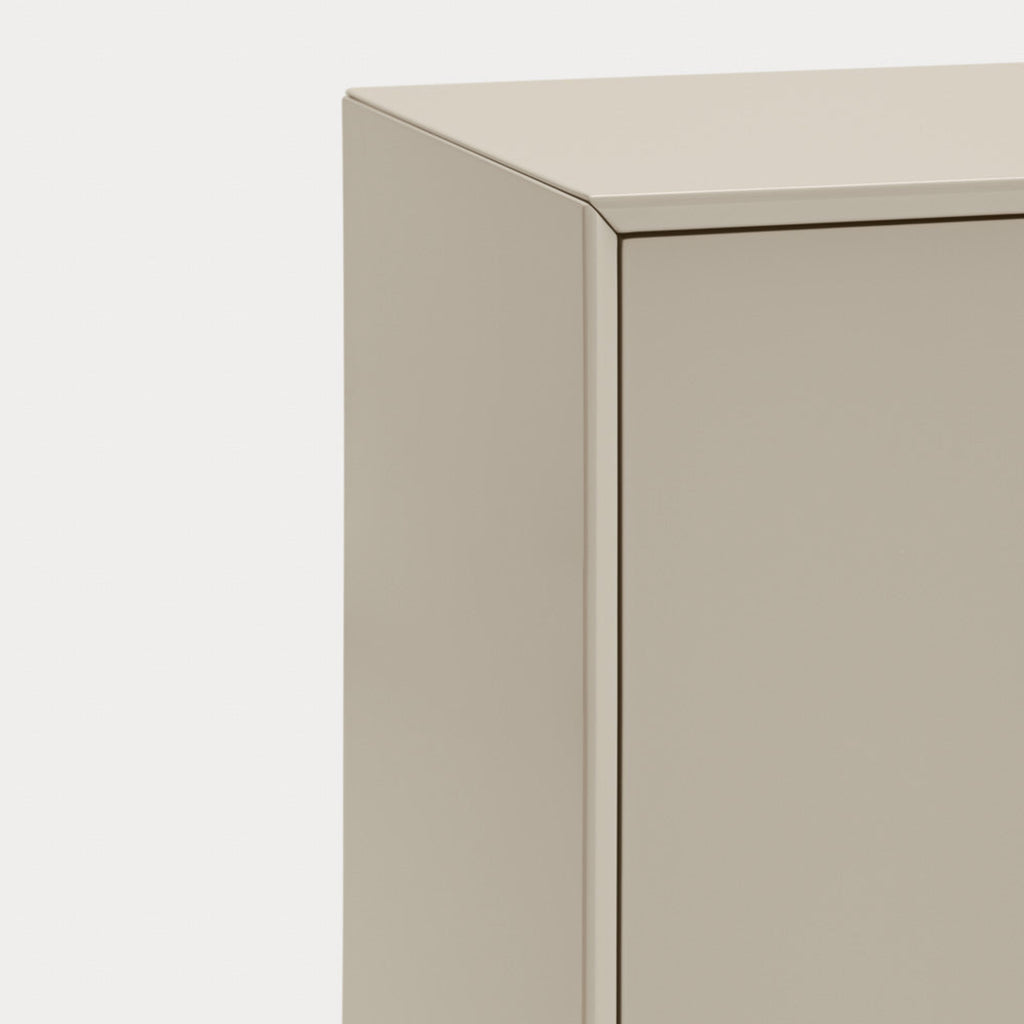 Close-up of a minimalist cabinet corner with a smooth, matte beige finish against a clean white background.