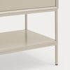 Close-up of a light beige or warm off-white furniture piece showing a drawer front, open shelf, and slim metal legs against a plain light background.