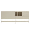 A modern sideboard cabinet with a light beige finish, featuring two large doors, a central open cubby, three drawers, and a lower open shelf on a slim metal frame, set against a plain light gray background.