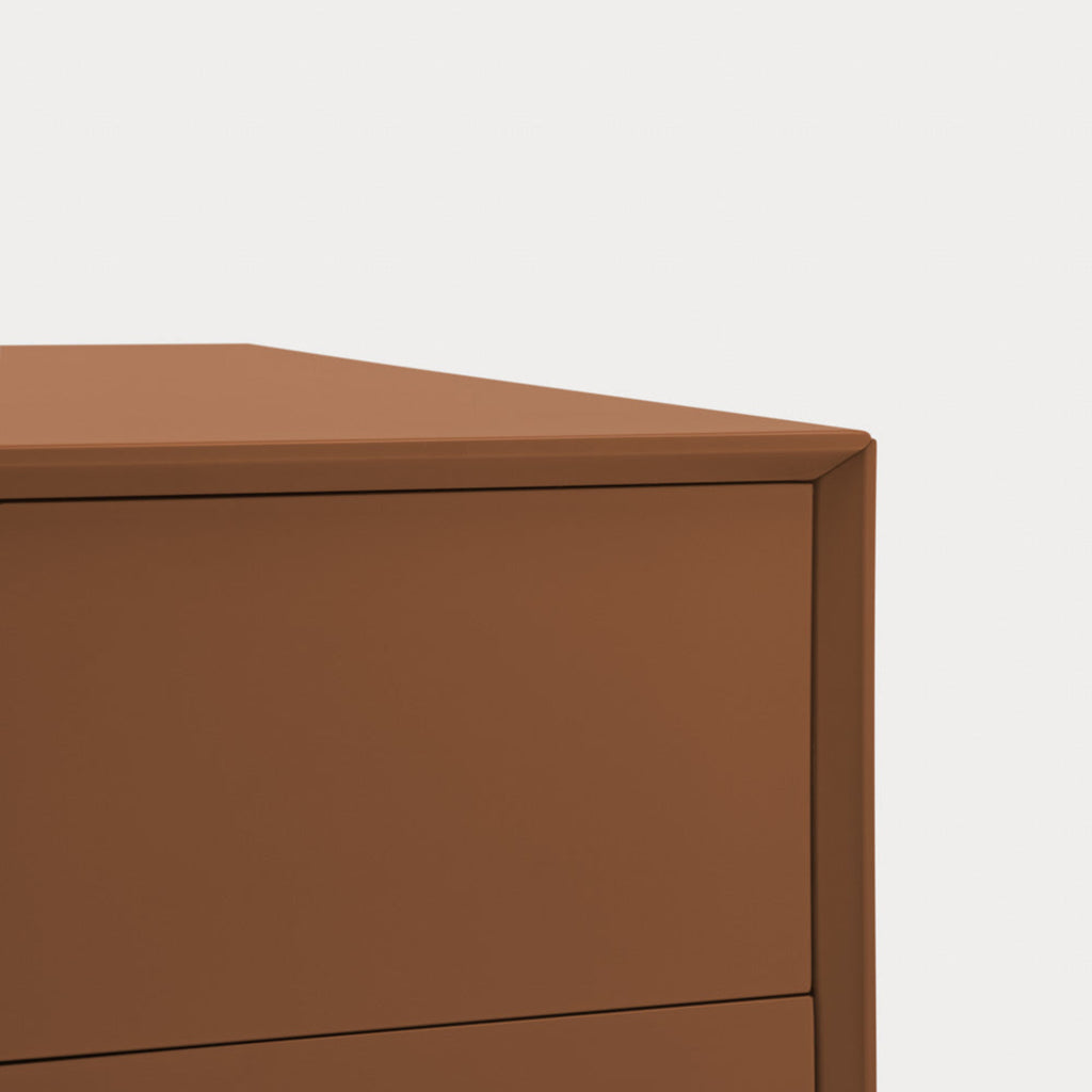 Close-up of a modern two-drawer cabinet or dresser in a warm medium brown finish, showing the top surface and drawer front against a plain light background.