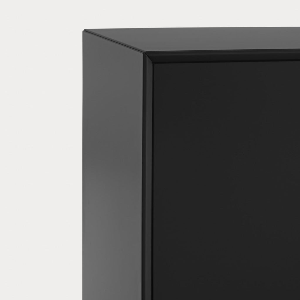 Close-up of a black rectangular product corner with a matte finish against a light gray background.