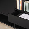 A close-up of a modern black bookcase or cabinet with an open drawer and open shelving holding books, set against a light beige floor.