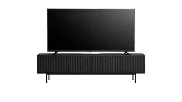 A modern black TV stand with a ribbed front and slim legs, supporting a large black flat-screen television, shown against a plain white background.